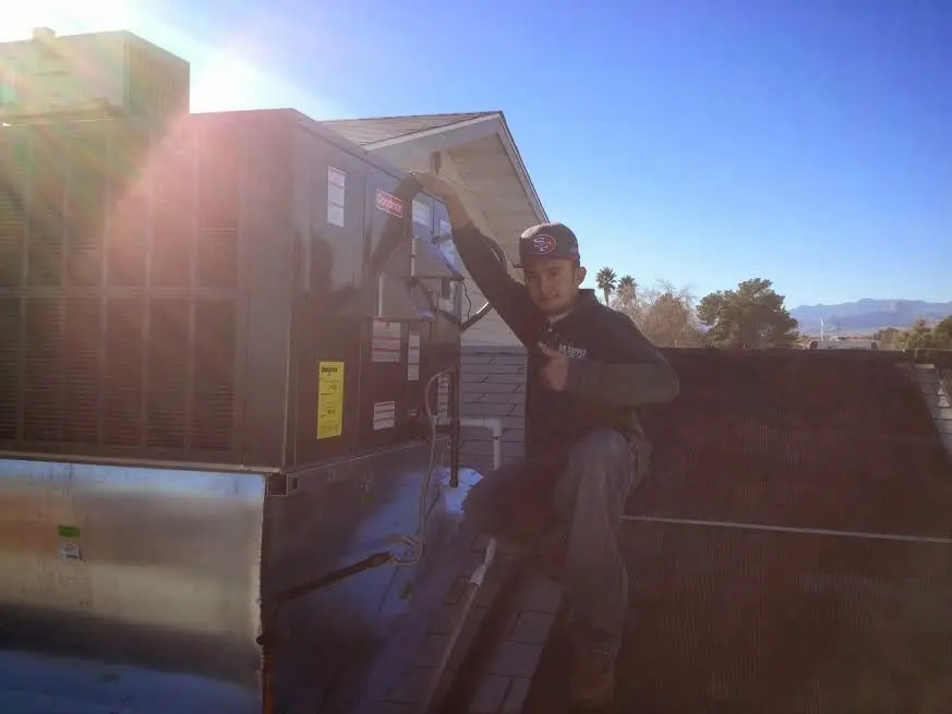 HVAC technician performing AC Tune-Up on a rooftop unit in Pearland